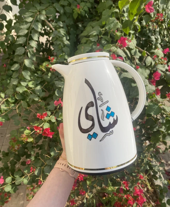 A sleek white thermos adorned with the word Tea